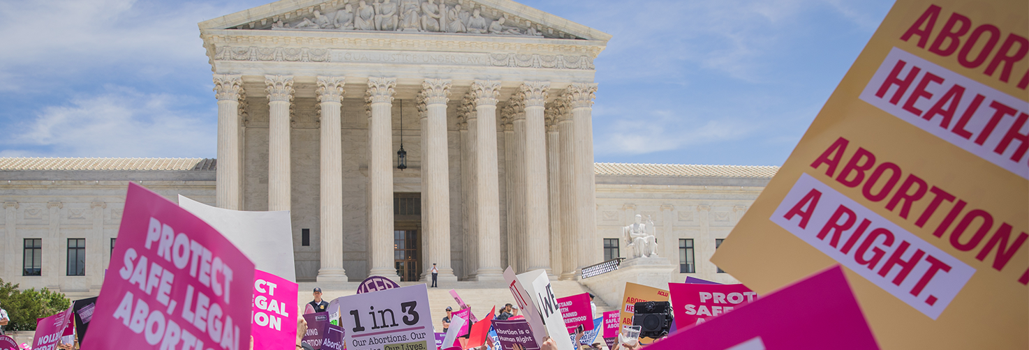 Reproductive Right rally crowd in front of Supreme Court with people holding pro-choice posters. 